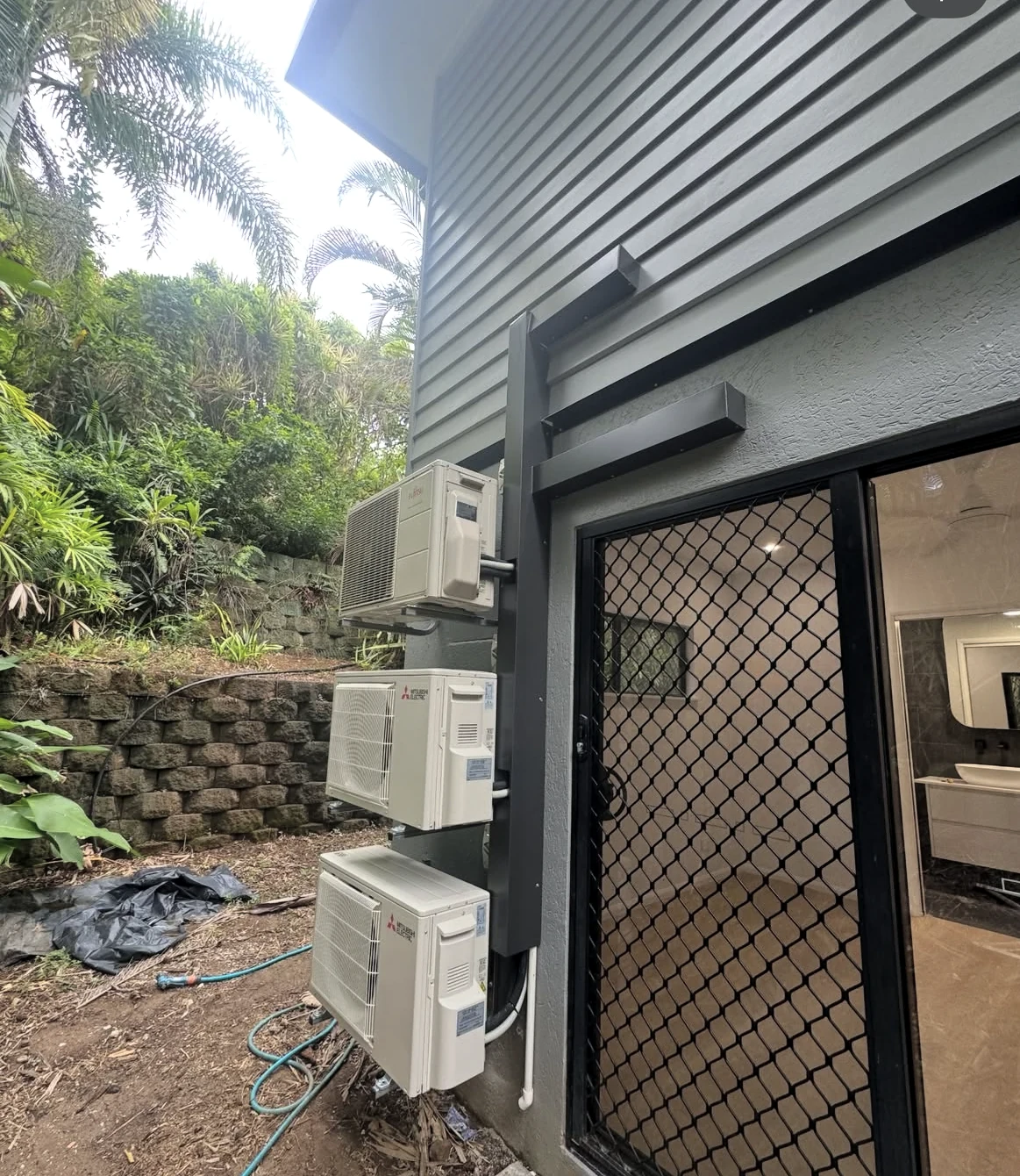 Air conditioning units installed on the exterior wall of a home